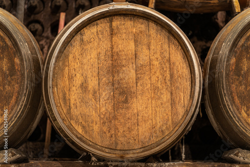 Tableau sur toile Wine cellar with oak barrels aging showing the concept of winemaking tradition