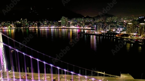 The gwangan bridge lights up the busan skyline at night over the water