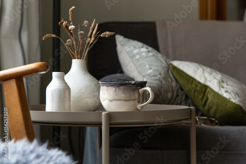 Side table with nature themed decor and a cup of tea or coffee.