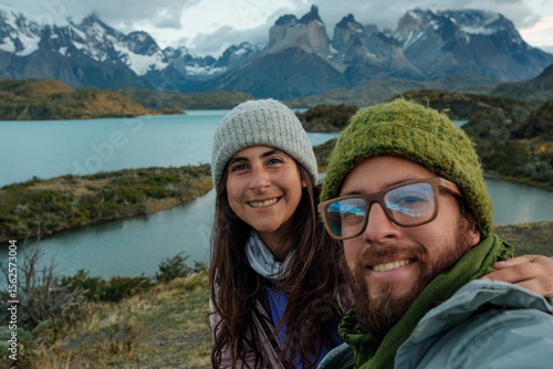young tourist couple taking a selfie with mountains  in the background