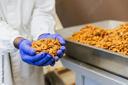 Close up of warehouse worker’s hands holding dried almonds