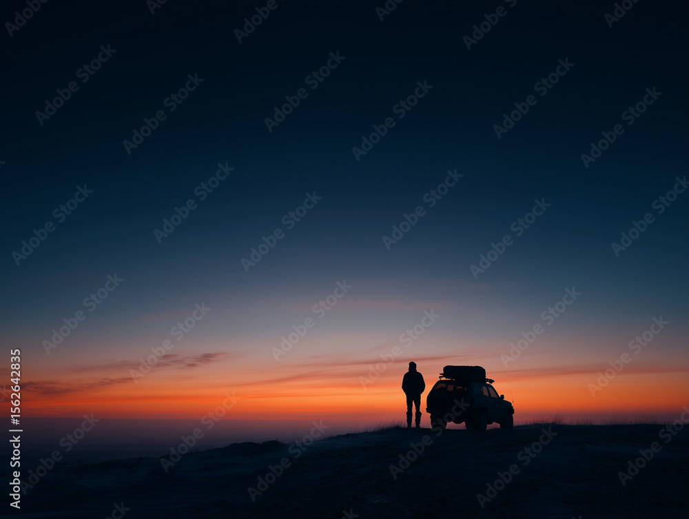 Fototapeta premium silhouette of person and small vehicle at arctic sunset
