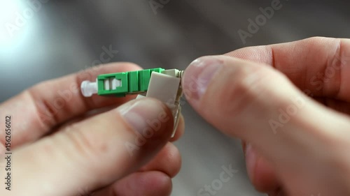 Stripped fiber optic cable being connected to an APC connector with a click-lock mechanism 