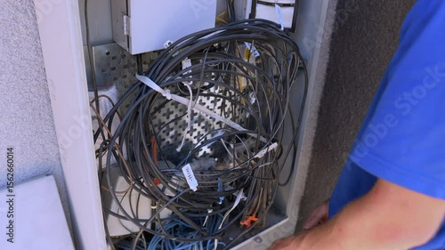 The Cable Technician secures the cables inside the Dmarc