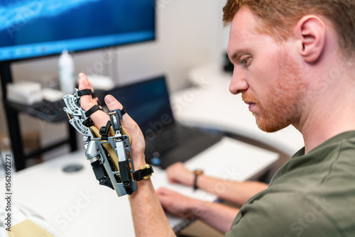 Engineer testing robotic hand prosthesis in laboratory