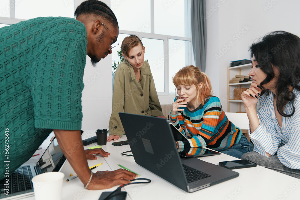 Fototapeta premium Young adult woman and colleagues working together in a modern workplace, socializing and collaborating on a business project with Gen Z coworkers.