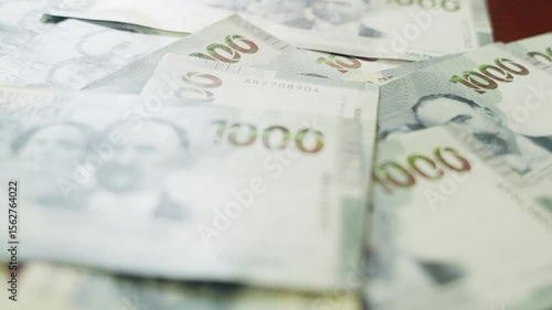 Money $1000 peso bills on a wooden table