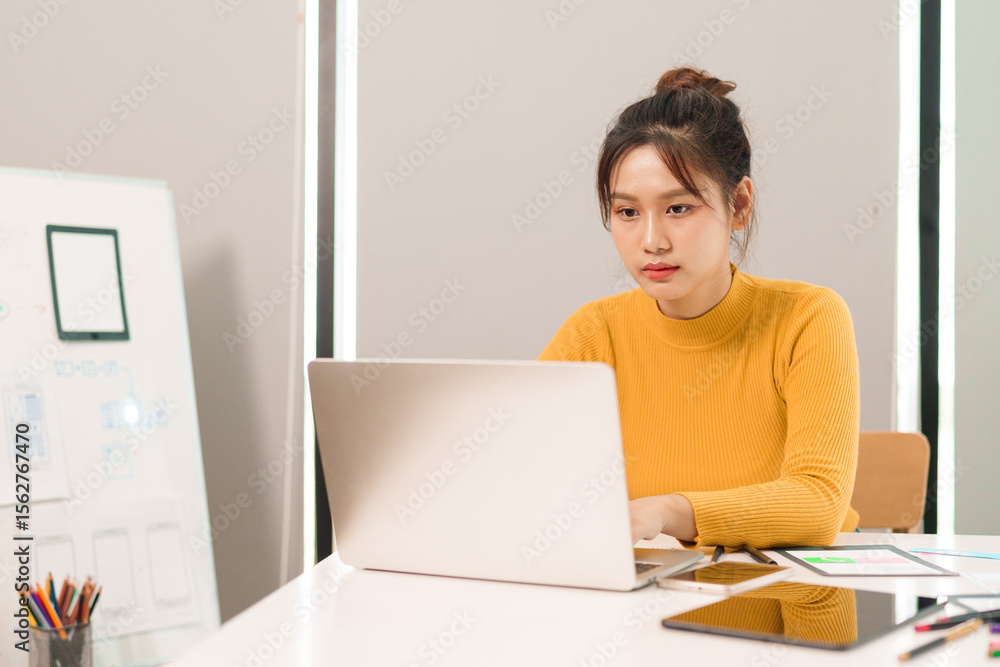 Young Asian UI UX Designer Working on Laptop Creating Mobile App Interface Web Design User Experience Prototyping Wireframing at Desk in Office Young Asian UI UX Designer Working on Laptop Creating Mobile App Interface Web Design User Experience Prototyping Wireframing at Desk in Office