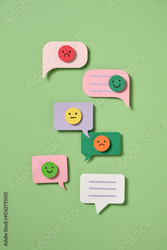 Paper cut-out speech bubbles with emoji faces range of emotions