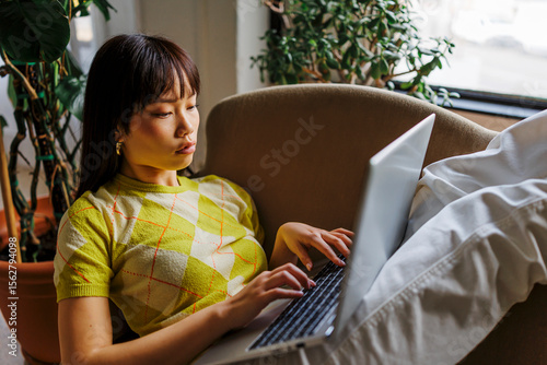 Woman studying remotely from home using laptop
