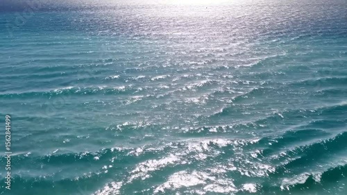 Ocean waves surface sunlight