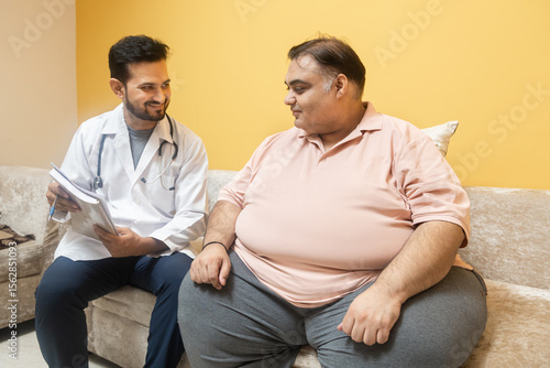 Male indian doctor consulting with overweight patient. Healthcare worker advice obese man to lose weight and discuss health risks of overweight. Obesity and Diabetes.