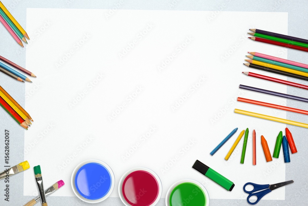 Obraz premium Flat design blank white sheet is lying on silver desk, framed by colored art supplies, scissors