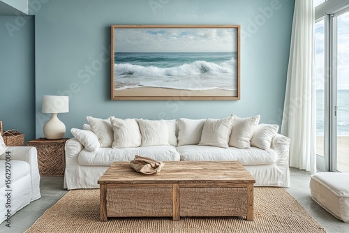 Fototapeta Naklejka Na Ścianę i Meble -  Coastal living room with ocean view, featuring a white sofa, wooden coffee table, and framed seascape art. Light and airy interior design.
