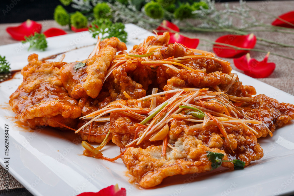 Crispy pot-fried pork in a white rectangular porcelain plate Crispy pot-fried pork in a white rectangular porcelain plate