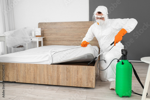 Male worker disinfecting be...