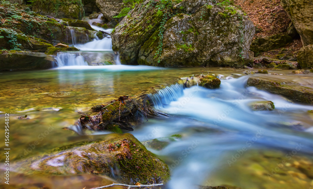 small waterfall on the mountain brook rushing over a stones small waterfall on the mountain brook rushing over a stones