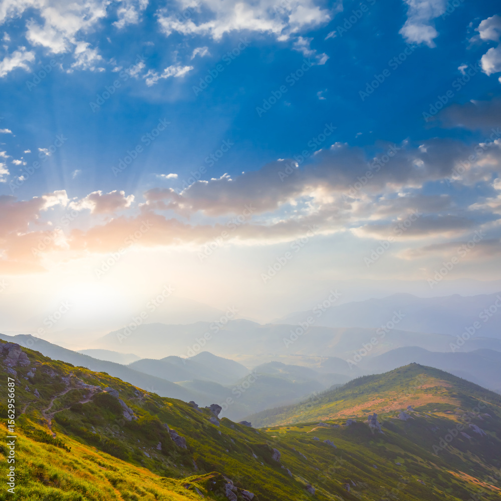 Fototapeta premium green mountain valley in clouds at the sunset, summer mountain travel scene