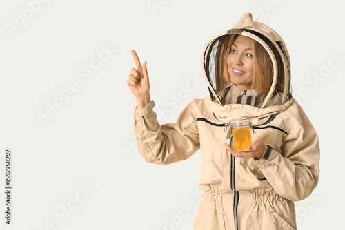Female beekeeper with jar o...