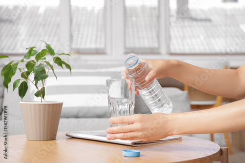 Woman pouring water from bo...