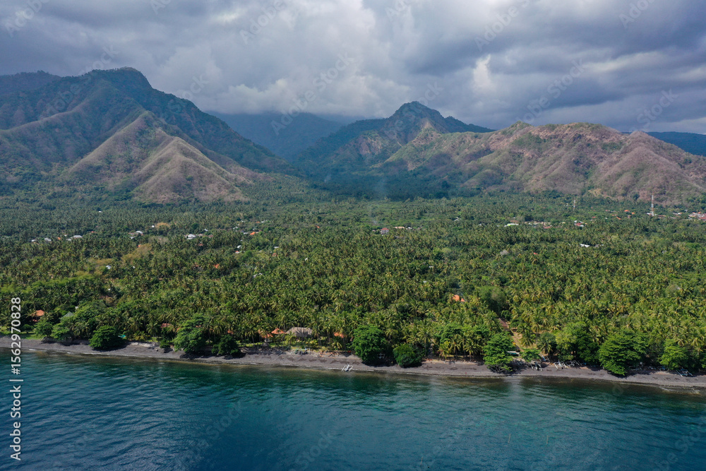 Dramatic Coastal Landscape of North Bali with Jungle Shoreline and Mountain Range Dramatic Coastal Landscape of North Bali with Jungle Shoreline and Mountain Range