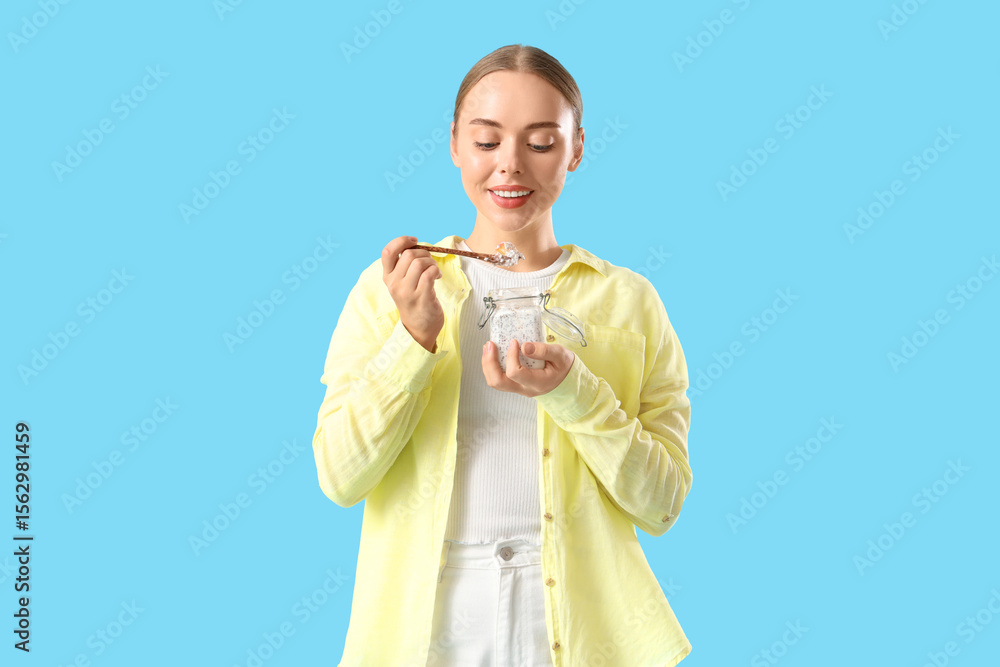 Young woman with chia seed pudding on blue background Young woman with chia seed pudding on blue background