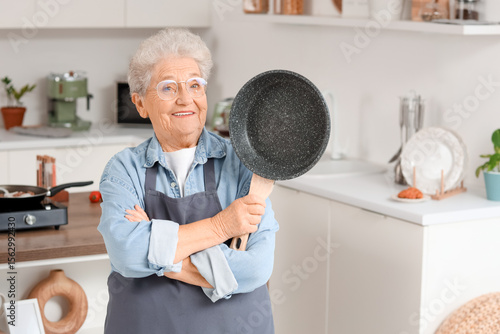 Senior woman with frying pa...