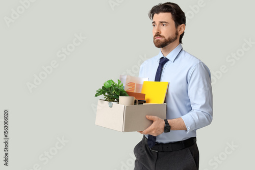 Fired young man holding box...