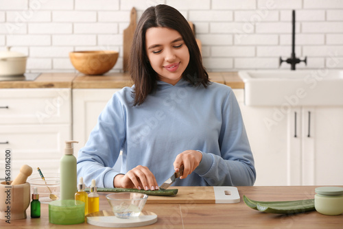 Young woman cutting aloe ve...
