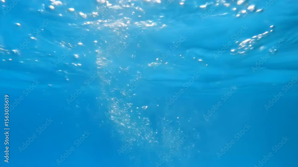 Diving into clear blue water with bubbles and ripples in a tranquil aquatic scene Diving into clear blue water with bubbles and ripples in a tranquil aquatic scene