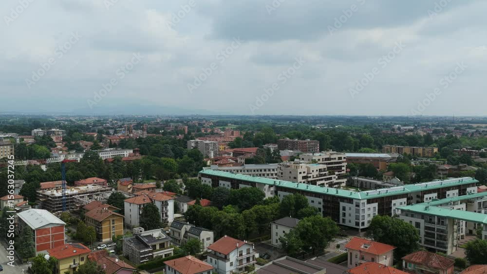 Aerial drone view of Vimercate, town in Lombardy, Italy, residential buildings, green trees, and cityscape under overcast sky, Brianza region. Copy space Aerial drone view of Vimercate, town in Lombardy, Italy, residential buildings, green trees, and cityscape under overcast sky, Brianza region. Copy space