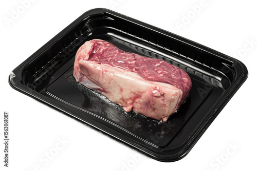 Raw marbled striploin steak in vacuumsealed plastic tray on black surface with a clean, modern presentation, showcasing fresh meat texture and rich colors