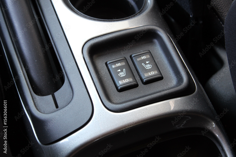 Front seat heating buttons on the cars central console. Seat heating buttons in the car interior. Double seat heating switch in a car. Front seat heating buttons on the cars central console. Seat heating buttons in the car interior. Double seat heating switch in a car.