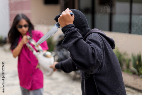 Thief in Black Threatens Woman with Knife While Snatching Her Bag on The Street.