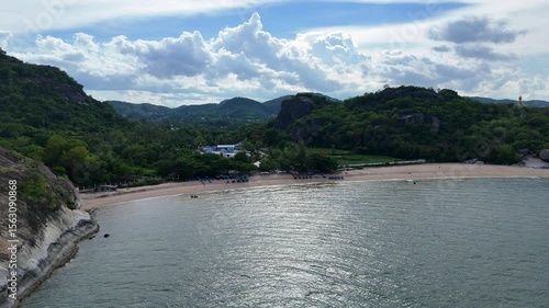 Thai beach surrounded by green hills and trees