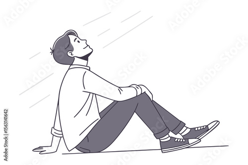 Young man sitting on the ground looking up with a hopeful expression contemplating the future with a sense of optimism and wonder