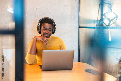 Smiling businesswoman doing video call sitting in office cubicle