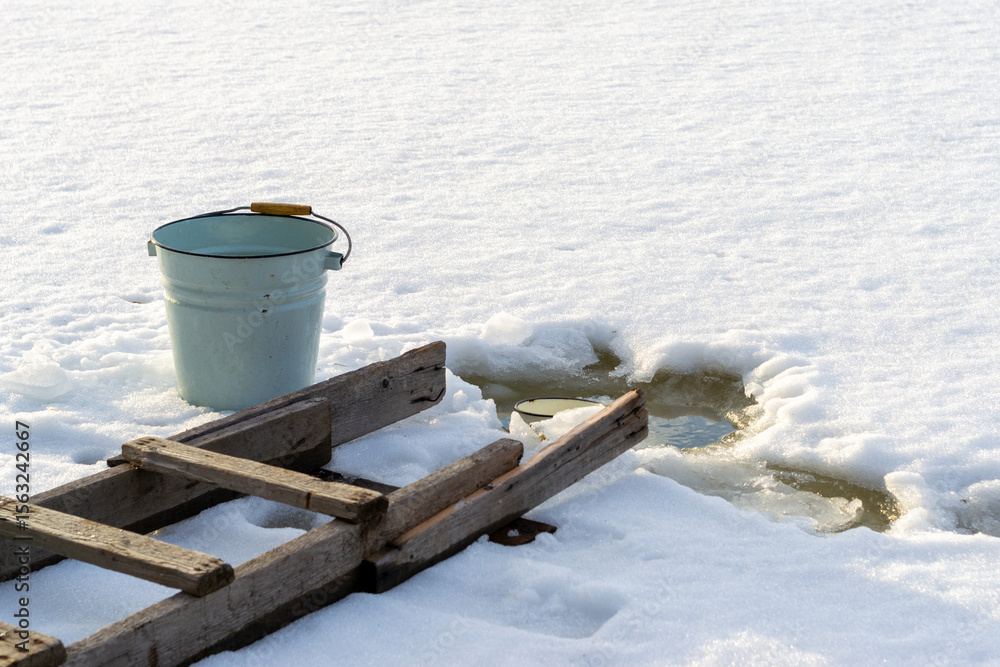 Naklejka premium Empty bucket stands at ice hole.