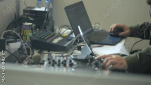Messy desk with a laptop and a keyboard. There are several wires and cords on the desk
