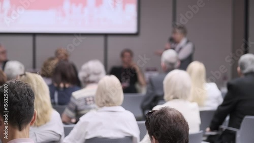 Wallpaper Mural Participants attending a professional conference with a speaker addressing the audience. The image showcases a corporate ambiance, with attendees focused on the presentation in a formal setting. Torontodigital.ca