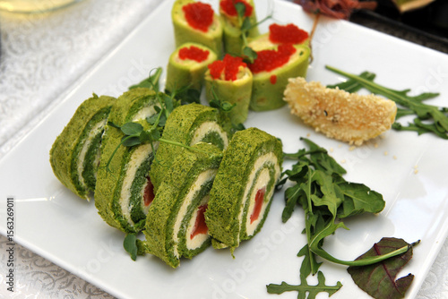 Green spinach roll filled and cream cheese and and beet slices. Dietary dish.