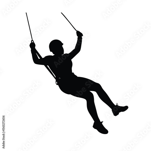 Silhouette of a rock climber rappelling downward depicting adventure and extreme sports