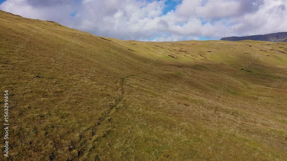 Aerial view of hikers on grassy hill, Faroe Islands. Aerial view of hikers on grassy hill, Faroe Islands.