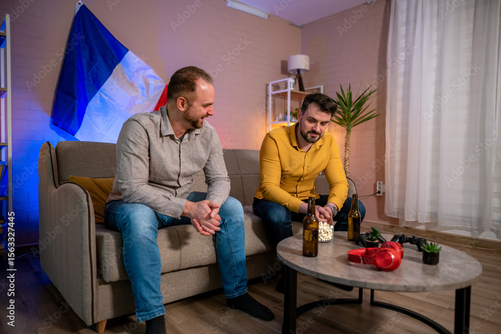 Friends enjoying drinks and snacks while relaxing at home Friends enjoying drinks and snacks while relaxing at home