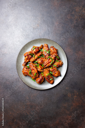Chicken wings in teriyaki sauce with sesame and onion. Asian food.