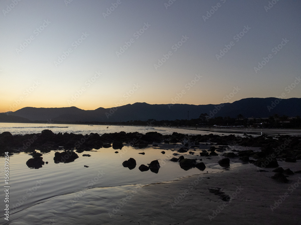 Naklejka premium Incredible orange sunset on a beach in the middle of the forest