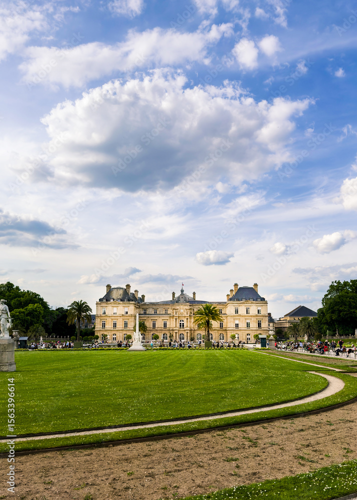 Fototapeta premium Classic building stands behind wide green lawn. Image is useful for architecture, travel, and tourism context.