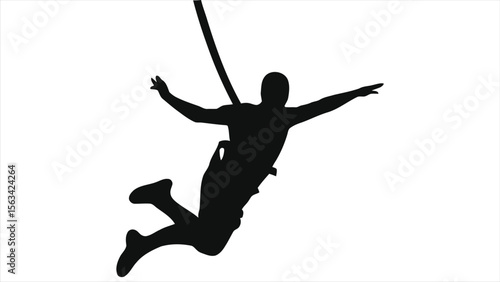 A silhouetted figure plummets through the light blue sky during a bungee jumping adventure