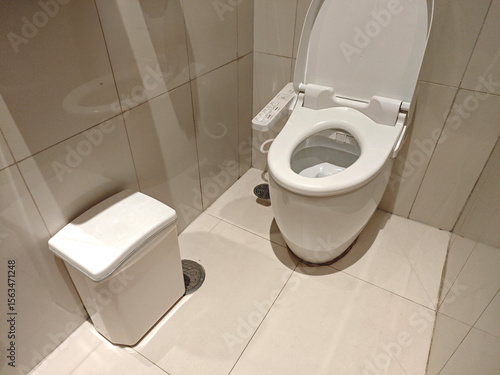 Modern bathroom interior with clean toilet and waste bin