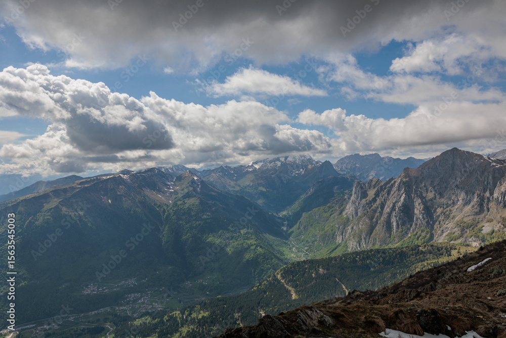 Naklejka premium vista panoramica su di un ambiente naturale di montagna tra le catene alpine del Friuli Venezia Giulia, di giorno, in primavera, con cielo parzialmente nuvoloso